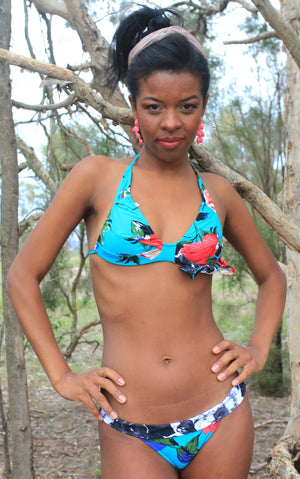 
                  
                    model wears blue triangle bikini with floral pattern in red
                  
                