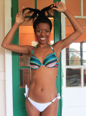 
                  
                    model wears a green striped booster bikini top with white tie side bikini bottom
                  
                