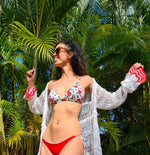 model wears floral bikini in white and red and white short long sleeve knitting beach cover with read detail on the sleeve