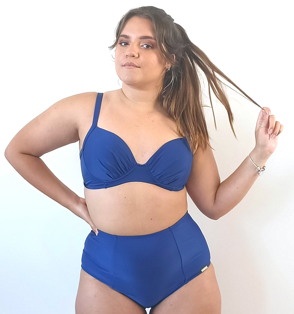 model wears blue booster bikini top with high waisted blue bikini bottom.