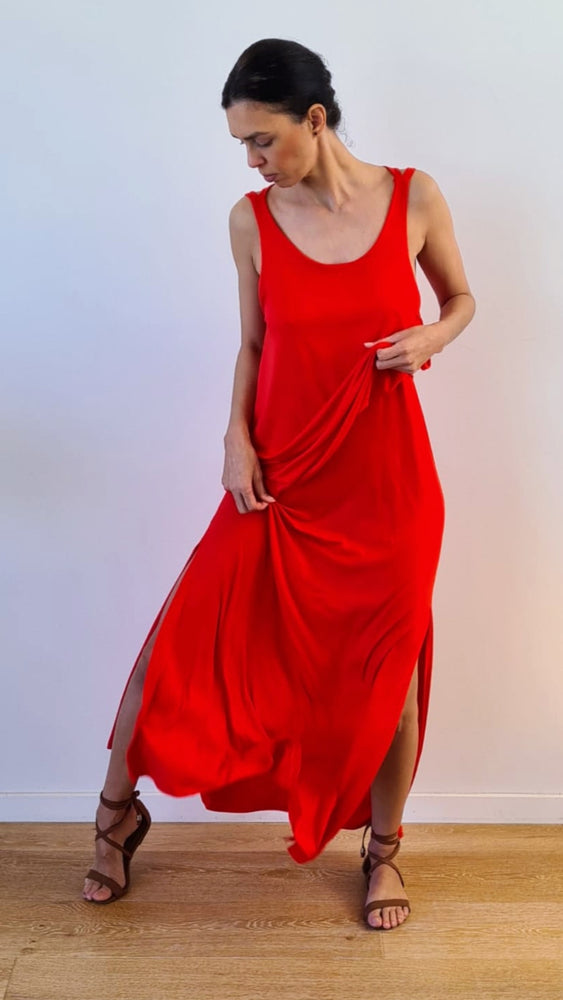 model wears long red dress in cotton, with openings on both legs.